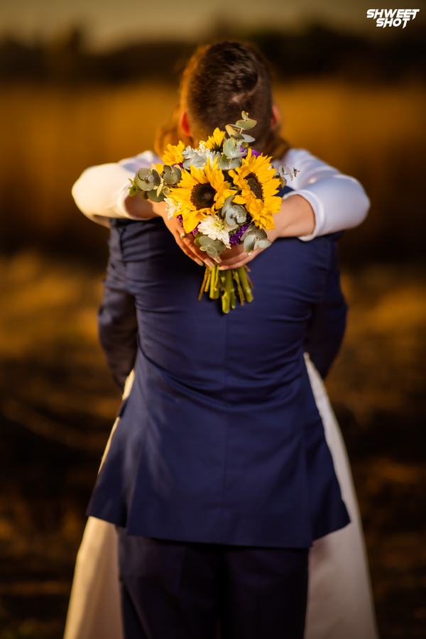 Groom lifting his bride with a sunflower bouquet